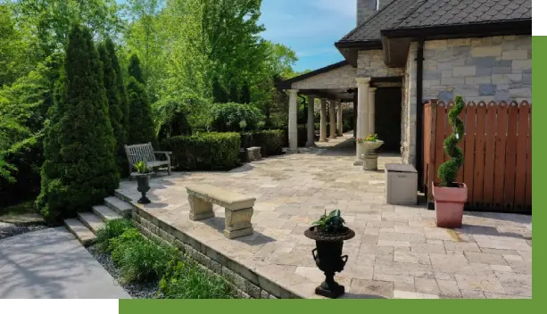 A patio with benches and potted plants in the background.